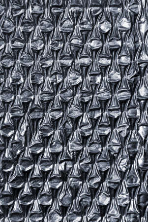 Background os a close up photo on a textured and reflective synthetic materialの写真素材