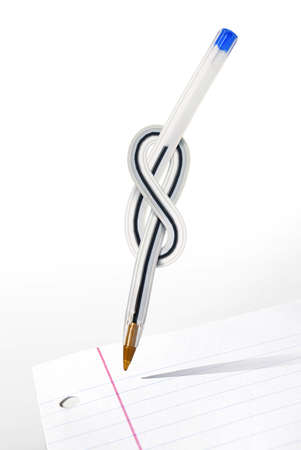 Conceptual image of a pen with a knot over a black sheet of paperの写真素材