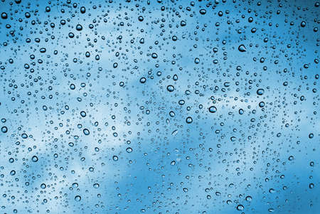 Background of water drops on a window glass in a rainy day の写真素材