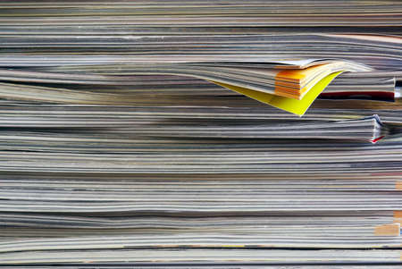 Closeup background of a pile of old magazines with bending pagesの写真素材