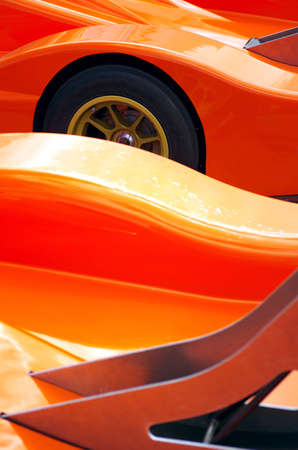 Details of two orange racing car body design showing spoilers a a wheelの写真素材