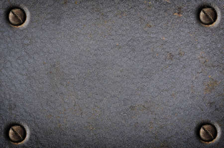 Old metallic surface with rusty screws in the corners