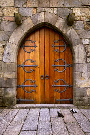 Beautiful old wooden door with iron ornaments in a medieval castleの写真素材
