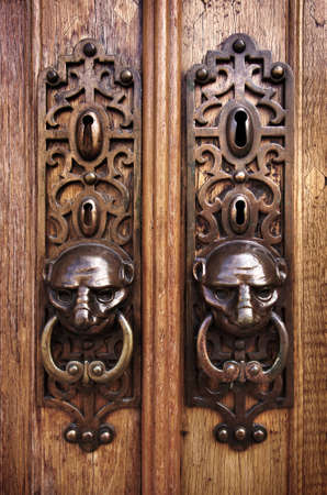 Two door knobs with knocking rings and animal heads in wooden doorsのeditorial素材