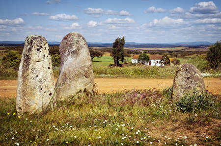 Megalithic menhirs and a white house in a rural landscape in Portugalの写真素材