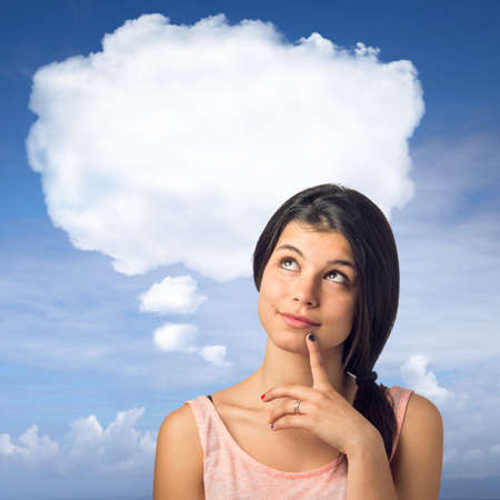 Pretty brunette girl in a thoughtful expression with a white cloud over her headの写真素材