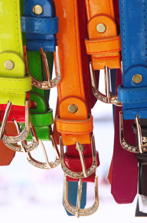 Assorted colorful leather belts with silver buckles hanged for saleの写真素材