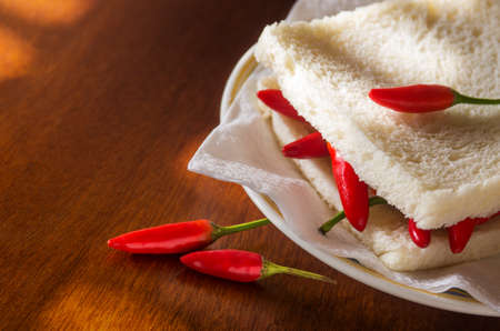 Closeup on a spicy hot chili pepper sandwich in a plateの写真素材