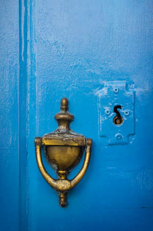 Old brass doorknob and keyhole in a blue doorの写真素材