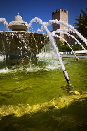 Closeup on water fountain and medieval castle in the background in a Portuguese villageのeditorial素材