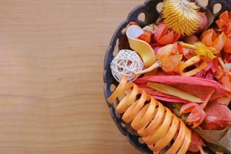 Colorful assorted potpourri in a bowl on a wooden tableの写真素材