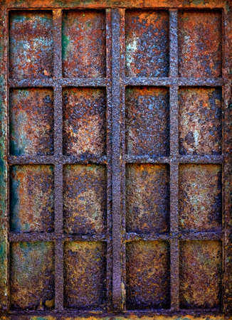 Background of grungy window with rusty iron bars and shutter plateの写真素材