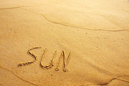 Summer concept of beach with word sun written on the sandの写真素材