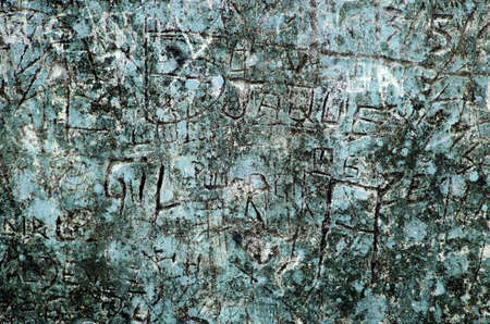 Grunge background of graffiti and sayings carved on a blue wallの写真素材