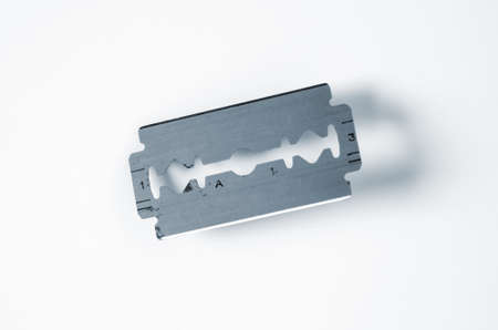 Closeup on an old razor blade over a white backgroundの写真素材