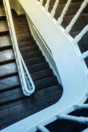 Looking down on old wooden stairway with white handrailsの写真素材