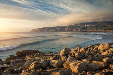 Seascape at Guincho beach and Cascais coastline, Portugal, with a group of surfers in the water.の写真素材