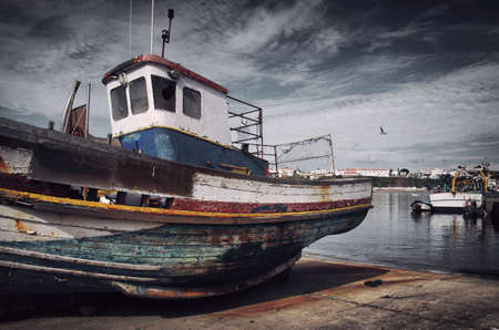 Old fishing boat with peeling paint in a dry dock in Sines, Portugalの写真素材