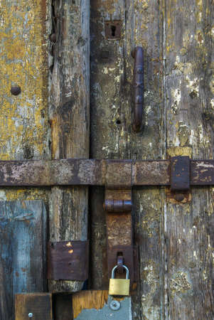 Detail of rusty metallic locks and padlock on an old wooden door