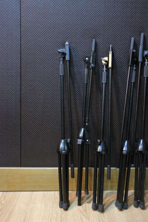 A group of black microphone stands inside a studio sound boothの写真素材