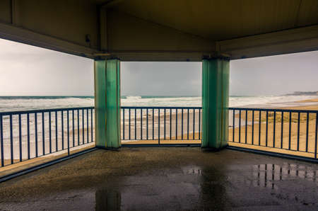 View through open windows of an empty beach in a overcast dayの写真素材