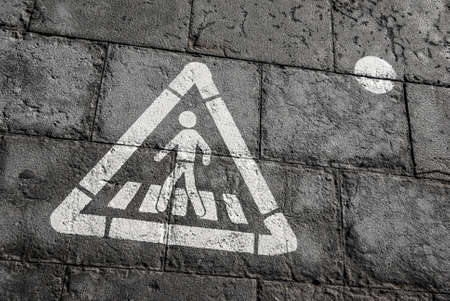 Walk sign, pedestrian street sign on a wet dark tile floorの写真素材