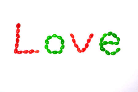word love written with red and green jelly beans isolated on white