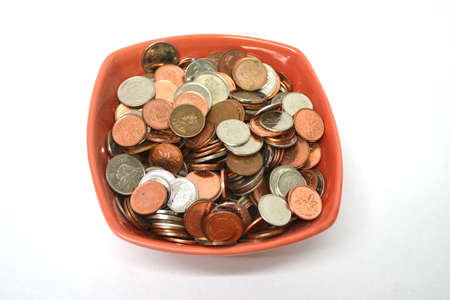 bowl of coins isolated on white backgoundの写真素材