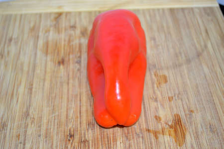 red bell peppers on wood cutting board close upの写真素材