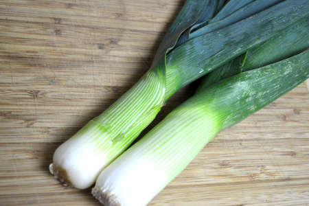 leeks on wood cutting board close upの写真素材