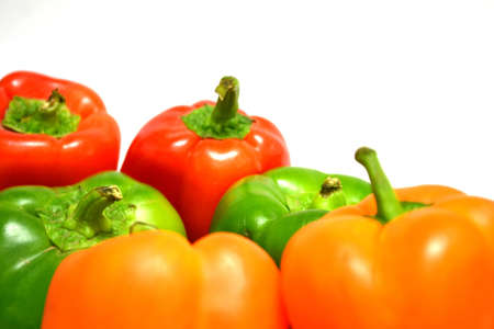 red orange and green peppers isolated on white background close upの写真素材