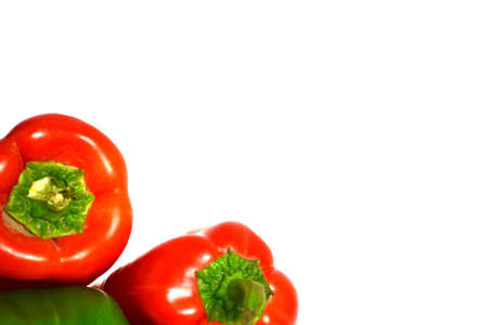 red peppers resting on top of green pepper isolated on white backgroundの写真素材