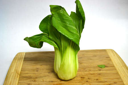 bok choy on wood cutting board isolated on white background close upの写真素材