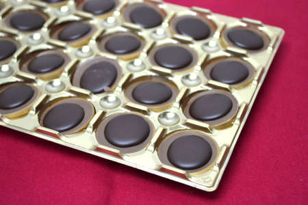 tray of chocolates isolated on red background close upの写真素材