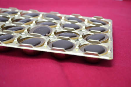 tray of chocolates isolated on red backgroundの写真素材