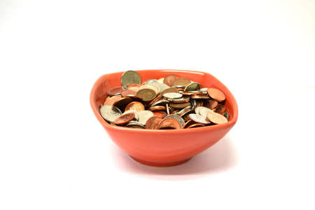 red bowl of coins isolated on white backgroundの写真素材