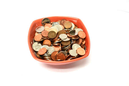 red bowl of coins isolated on white background close upの写真素材