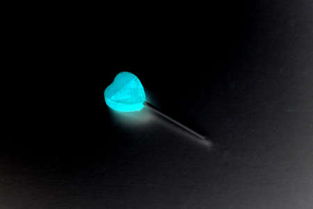 glowing heart on a stick isolated on black backgroundの写真素材