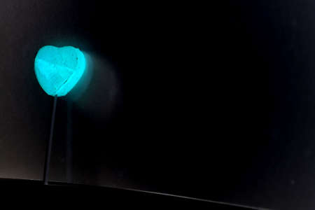 glowing heart on a stick isolated on black backgroundの写真素材
