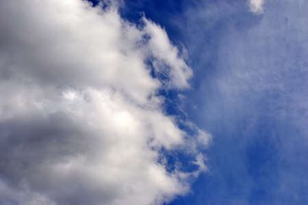 blue sky with fluffy white and gray cloudの写真素材