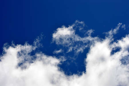 Fluffy white clouds on a bright blue skyの写真素材
