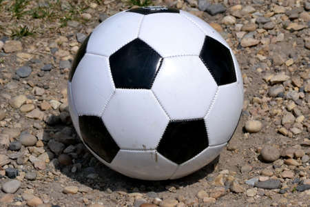 Soccer ball isolated on gravelの写真素材