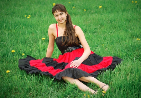 Girl in red dress on the grassの写真素材
