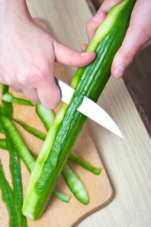Cucumber peeling in the kitchenの写真素材