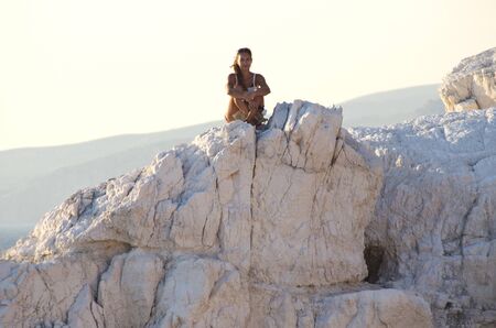 Woman sitting on the top of white rock, Zakynthos, Greeceの写真素材