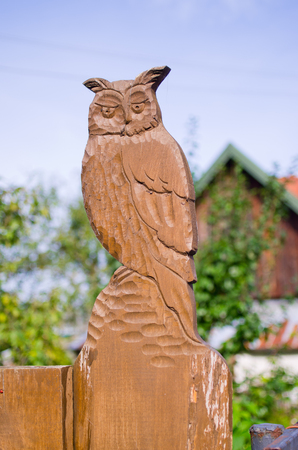 Wooden owl statue on the fenceの写真素材