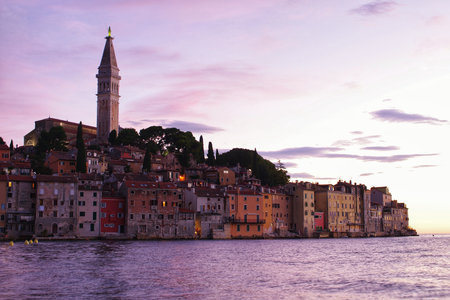 Experience the magic of a charming coastal town bathed in twilight hues. Serene waters reflect the soft glow of dusk, creating a tranquil and romantic atmosphere perfect for travel and lifestyle themes.の写真素材