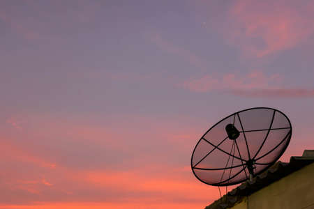 Satellite dish on the roof in eveningの写真素材