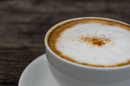 Hot cappuccino coffee cup on wooden table on brown backgroundの写真素材