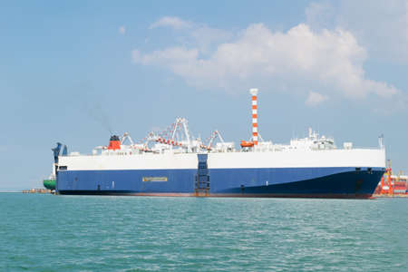 Huge container cargo ship on harbor with blue sky background
